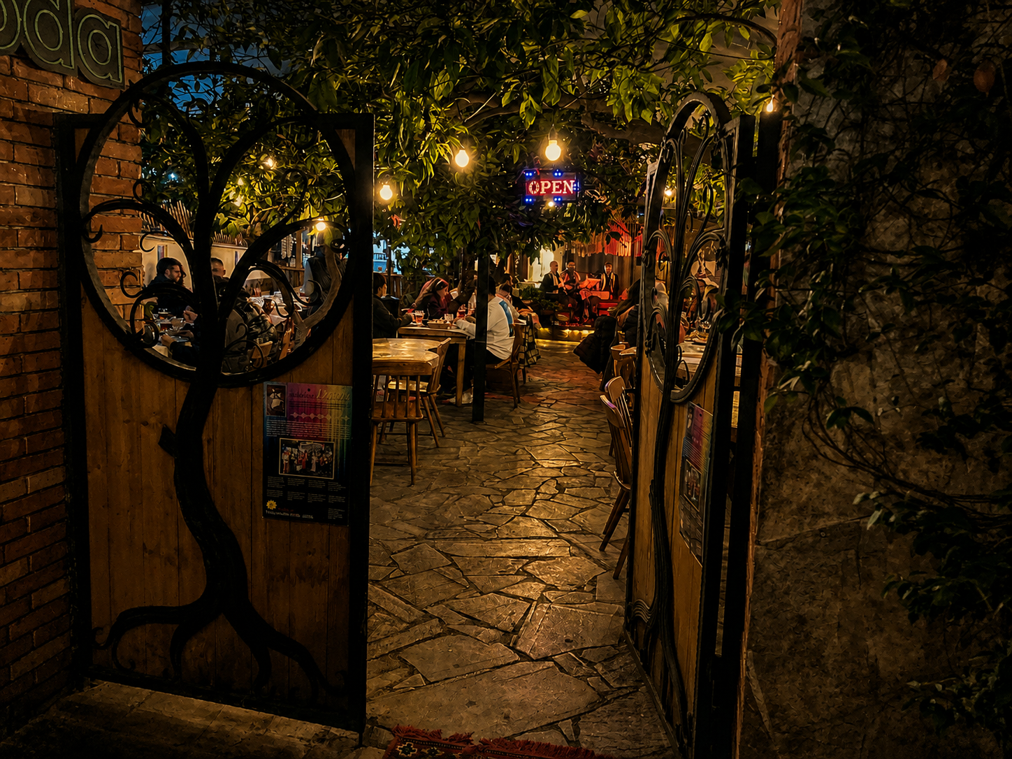 ODA Restaurant – Eingang mit geöffnetem Holztor und Gastgarten